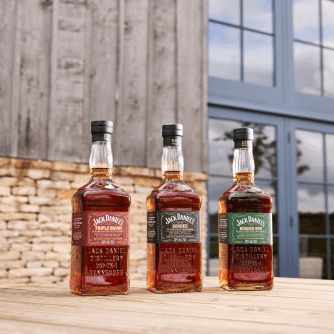Picture of the three bottles of the jack daniel's bonded series in front of the jack daniel's distillery