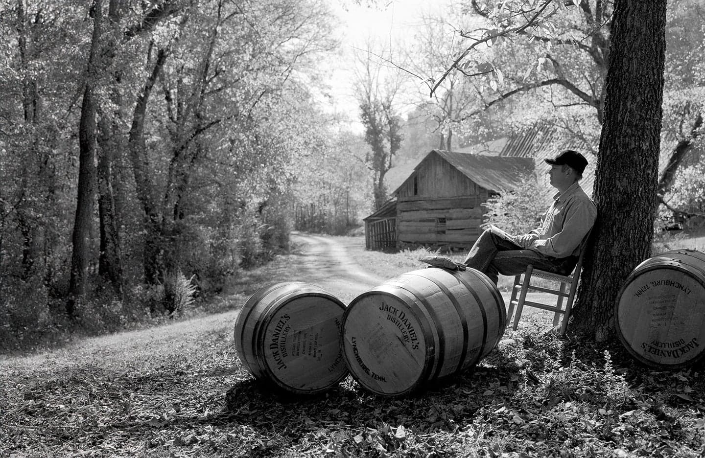 Our History - Man sitting with barrels under a tree